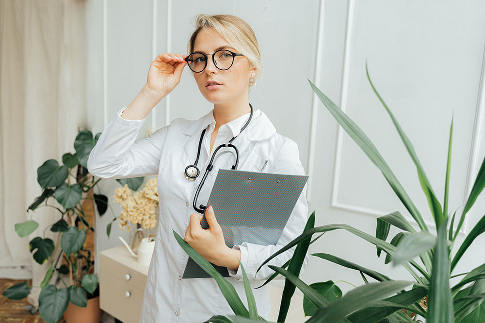 nurse in white robe and glasses posing